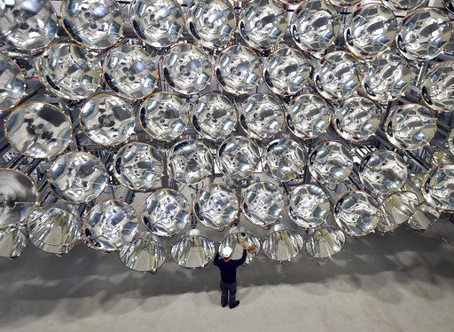 In this March 21, 2017 photo engineer Volkmar Dohmen stands in front of xenon short-arc lamps in the DLR German national aeronautics and space research center in Juelich, western Germany. The lights are part of an artificial sun that will be used for research purposes.
